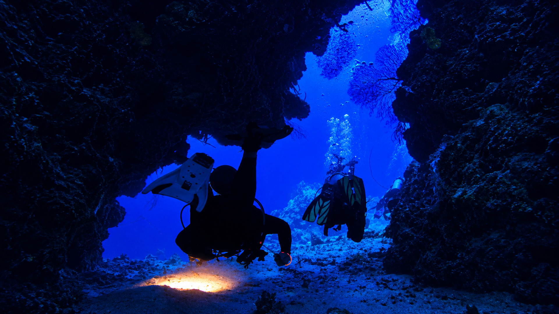 Scuba diver moving through a reef passage in Cozumel