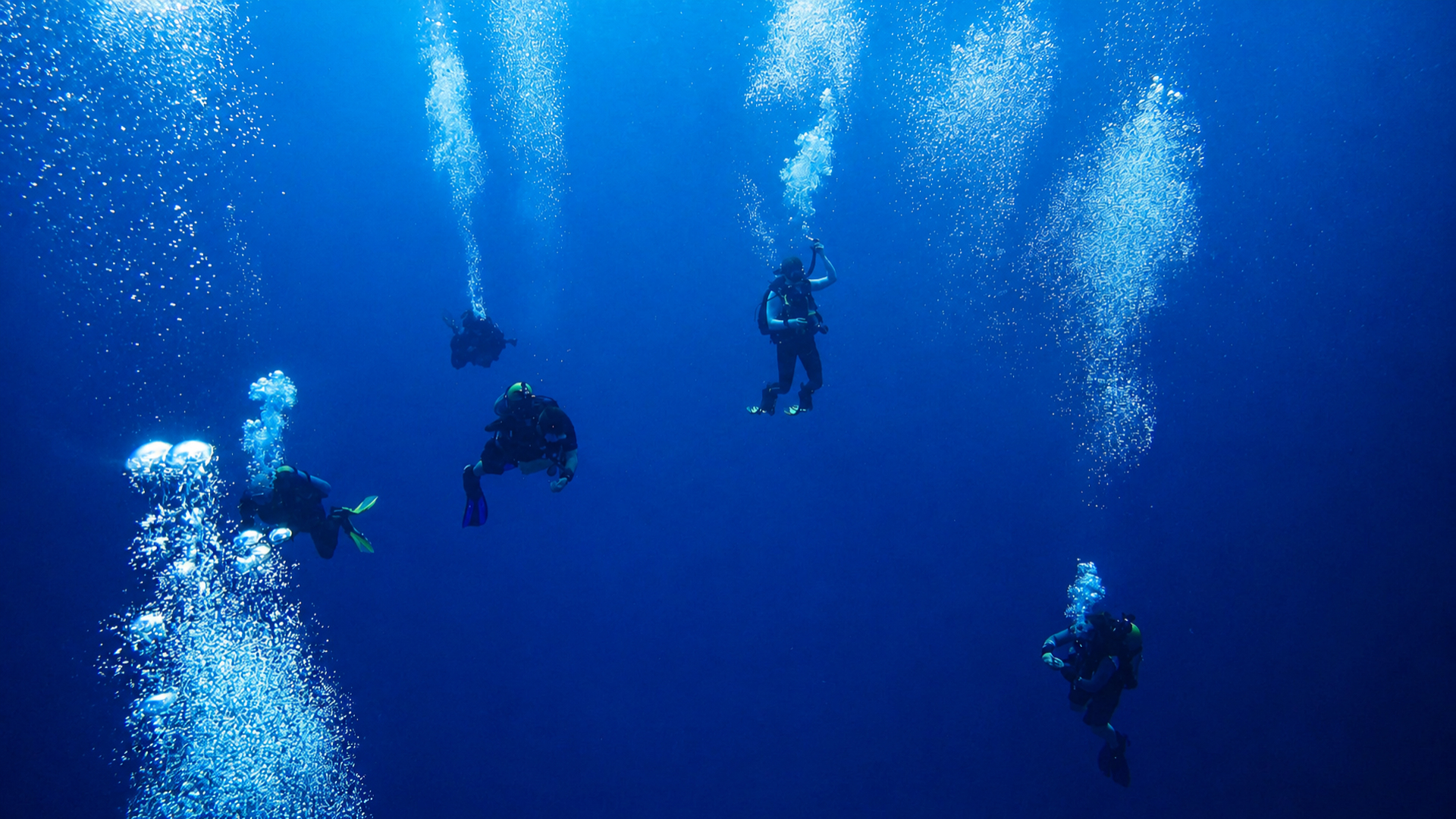 Diver and bubbles rising into blue water