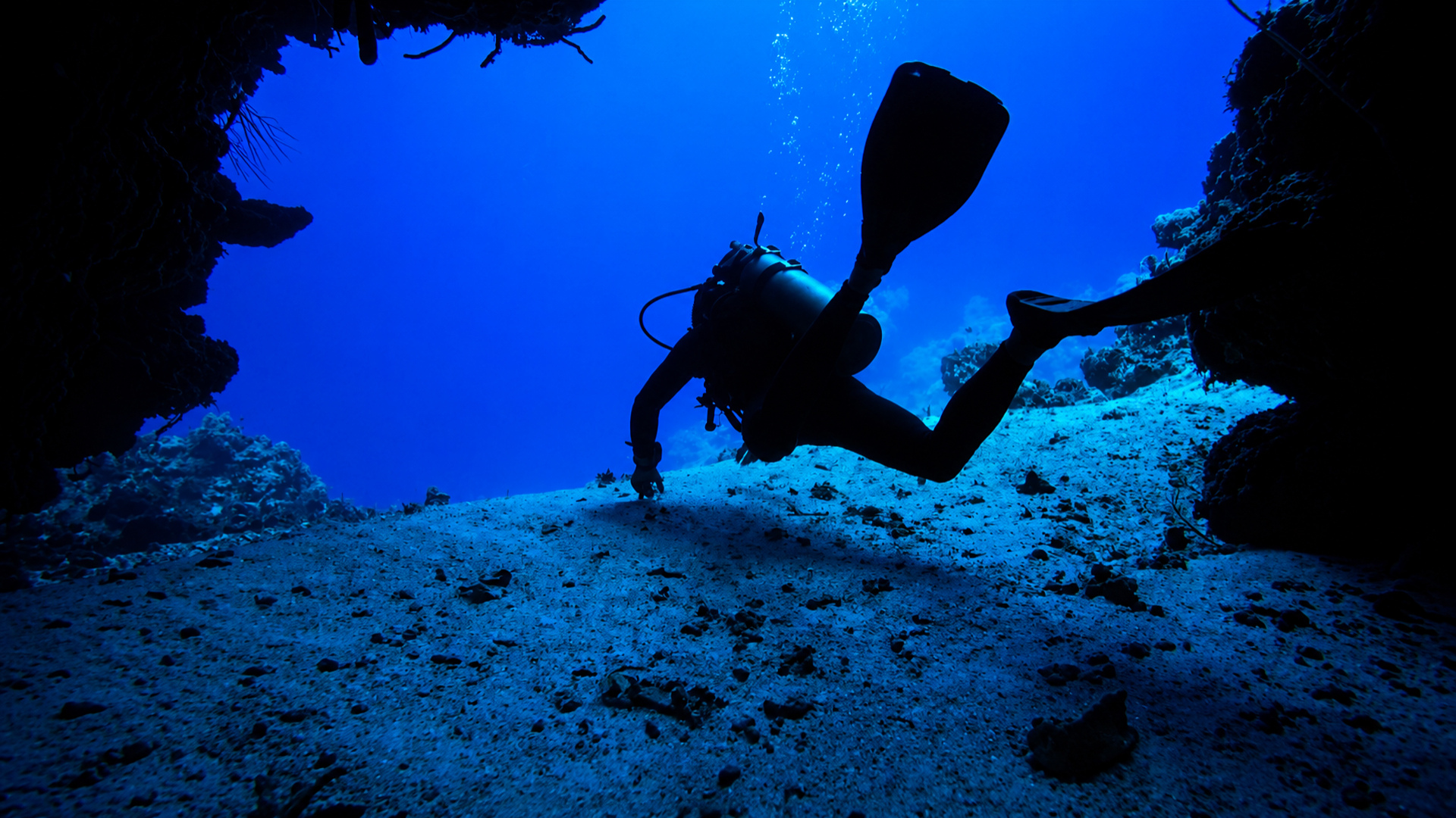 Divers framed inside a Palancar swim-through