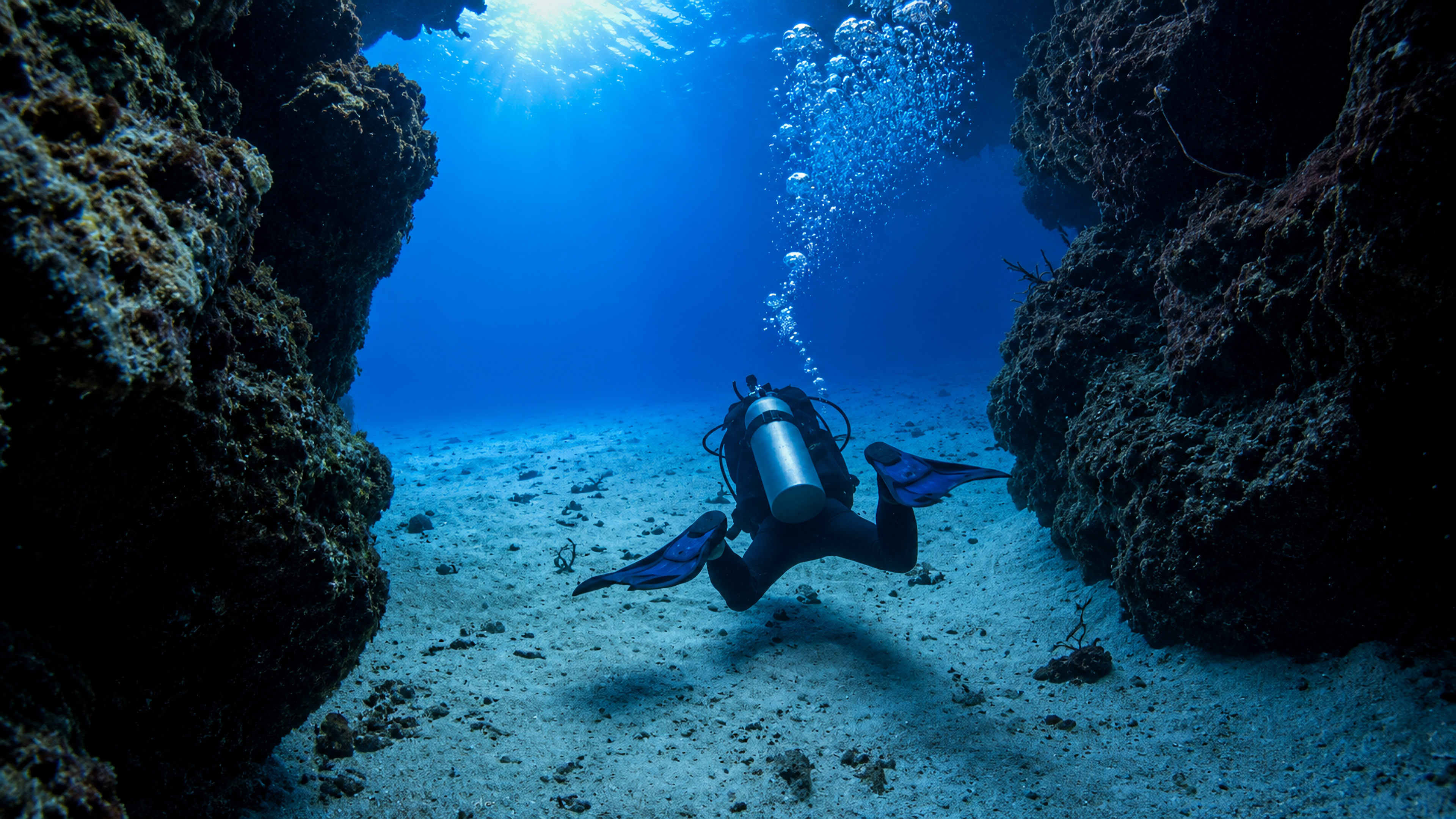 A diver crossing a sandy channel between Palancar coral formations